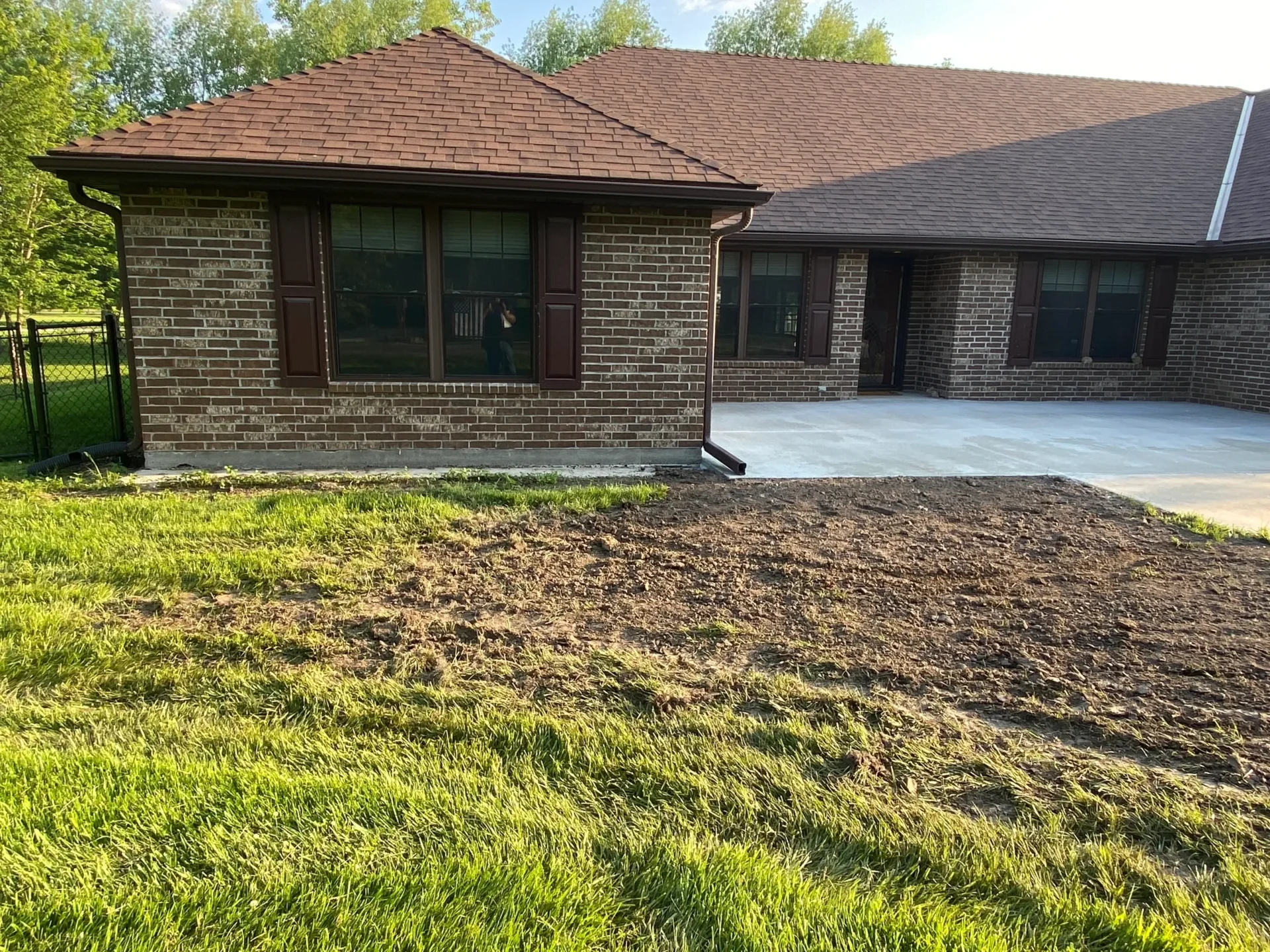 A house that is being remodeled with grass growing.