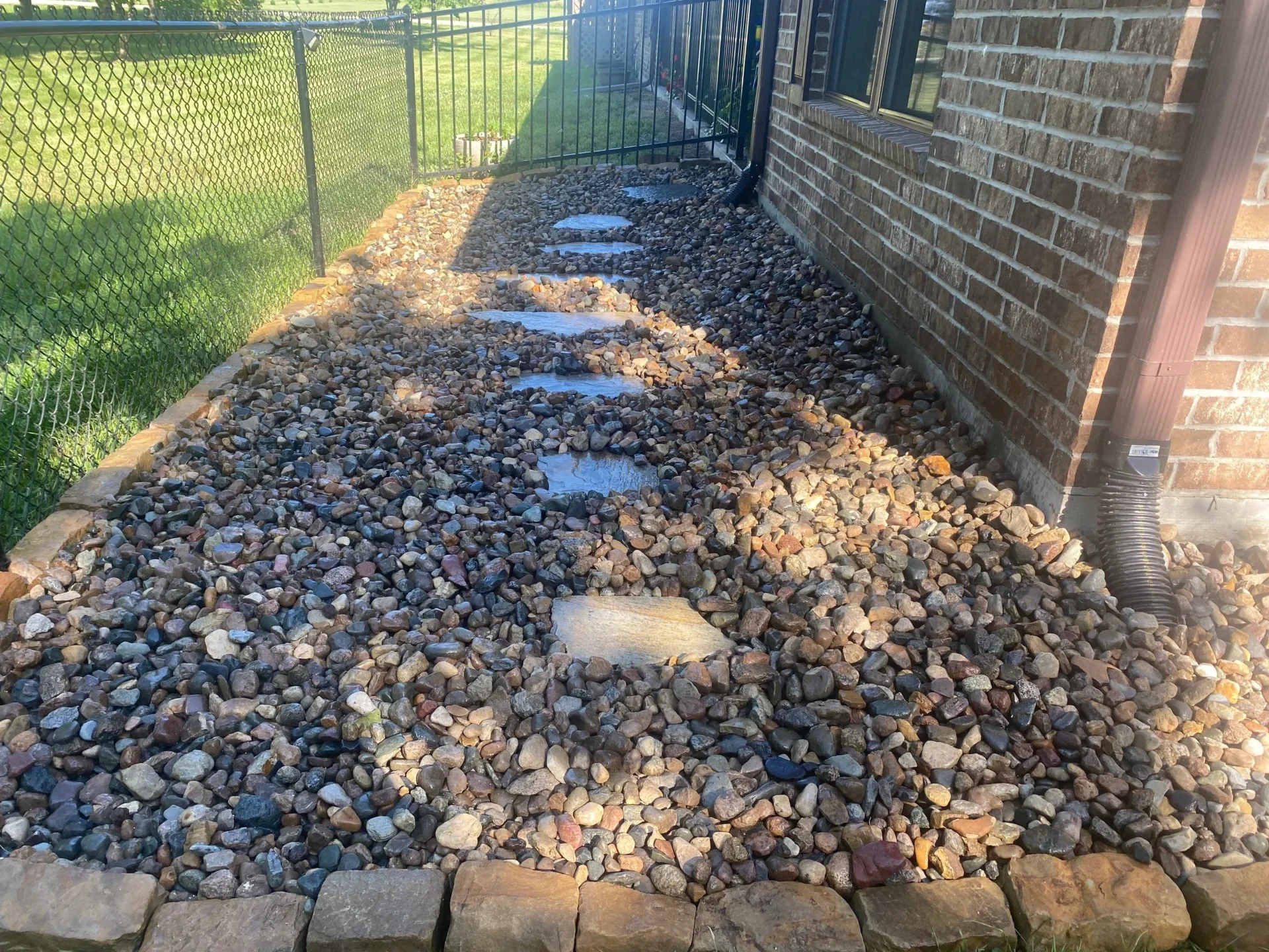 A brick walkway with rocks and bricks in the middle of it.